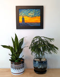 original oil painting of Erie Pierhead light house silhouetted by beautiful sunset and clouds, painted on 11 x 14 canvas panel, framed in modern black frame, displayed on wall over table