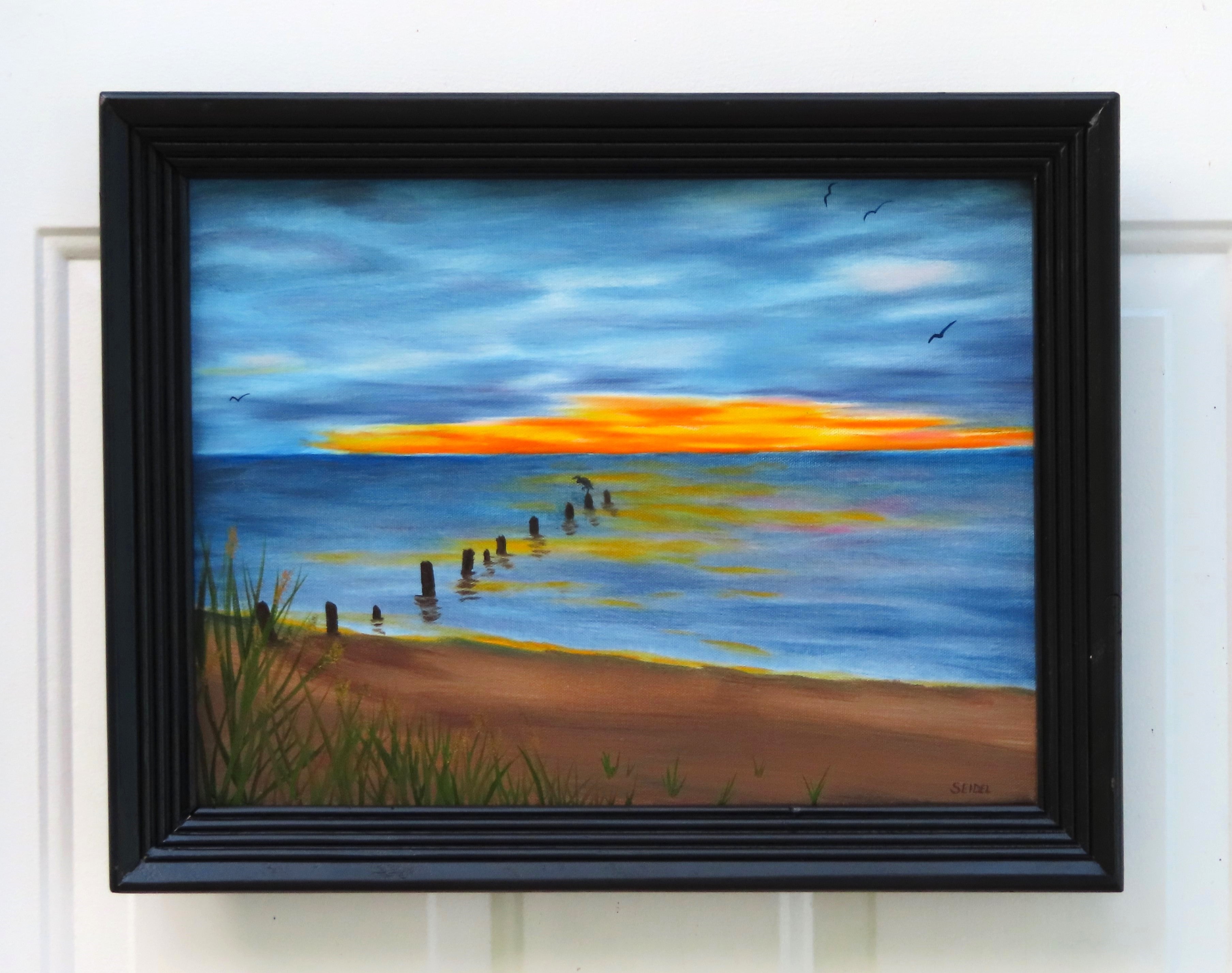 framed painting of beach and sunset