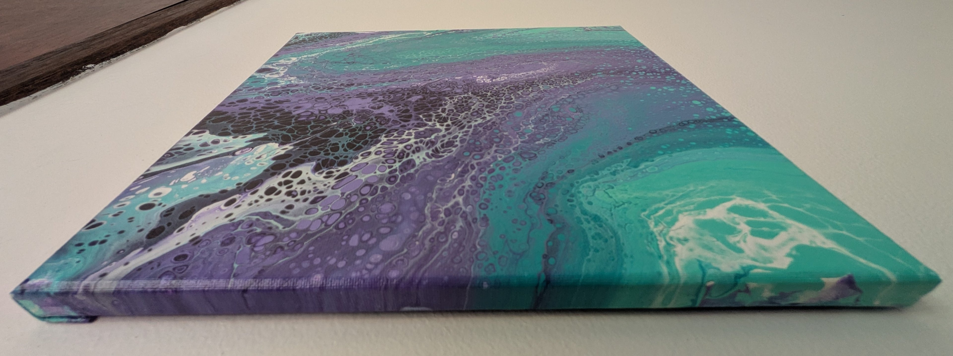 abstract liquid acrylic paint on 12x12" canvas, blues, greens and purples mix and flow in endless movement, can display in various directions, top side