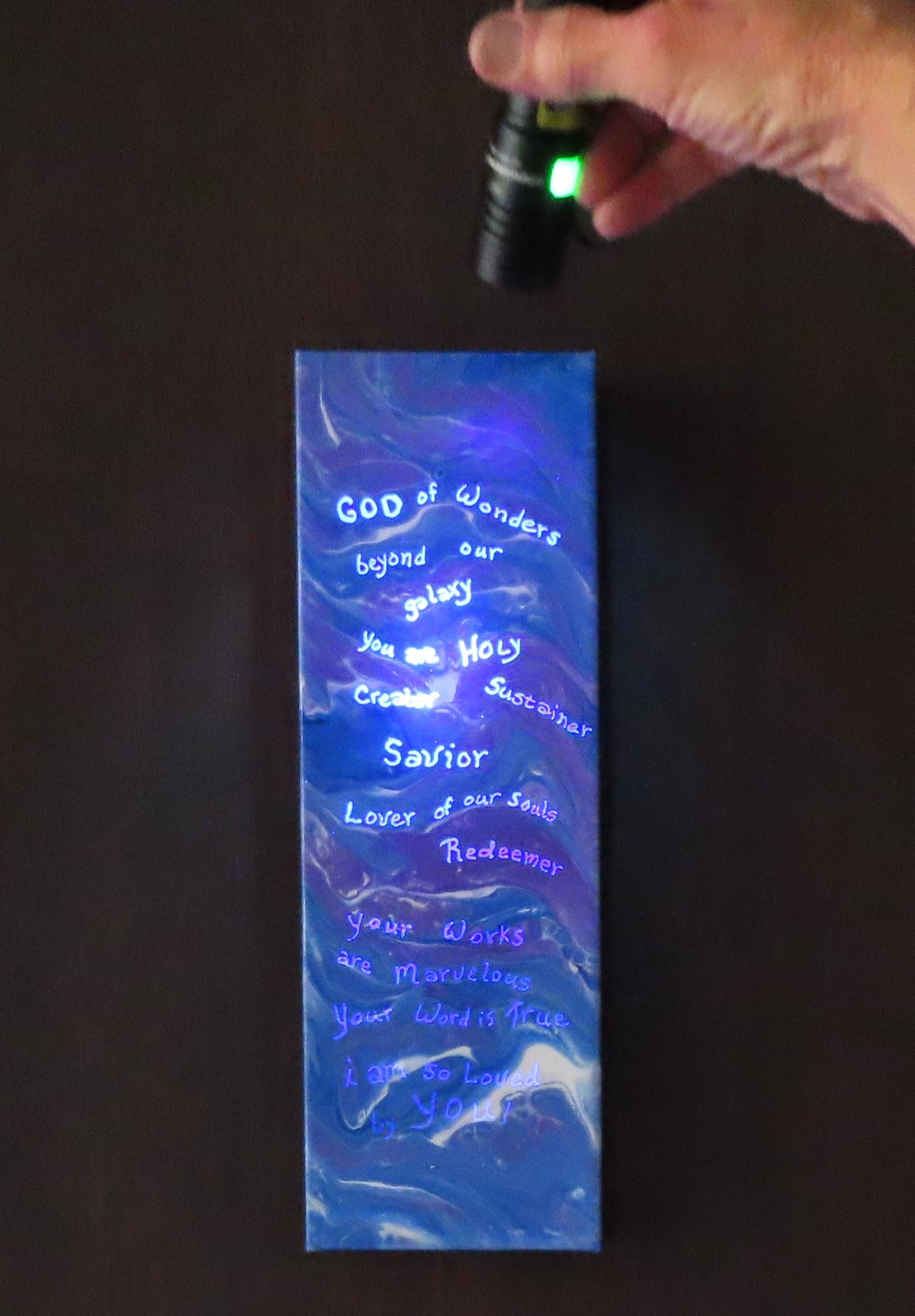 4 inches wide by 12 inches tall, liquid acrylic painting with blues, purple and white, shown here with the secret message lit up with the black light.