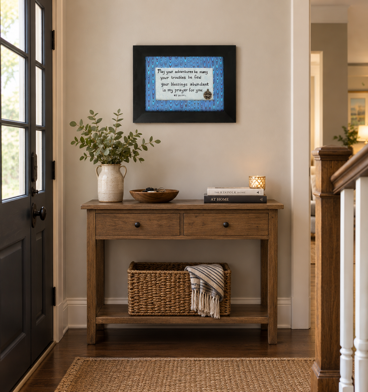 5x7" original inspirational quote hand written on handmade paper, included is a small compass charm and a handmade padded multicolor mat, mounted in a modern black frame, shown in a entryway of a home