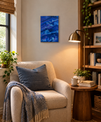 9x12" original abstract acrylic poured painting of an alien landscape in rich blues, purples and white accents, can be displayed in different directions. Shown here in a reading nook.