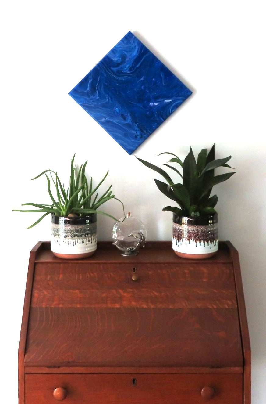 abstract acrylic liquid art on 12x12" canvas, rich blues, purples and white accents. Can be displayed in any direction, shown here over a secretary desk.