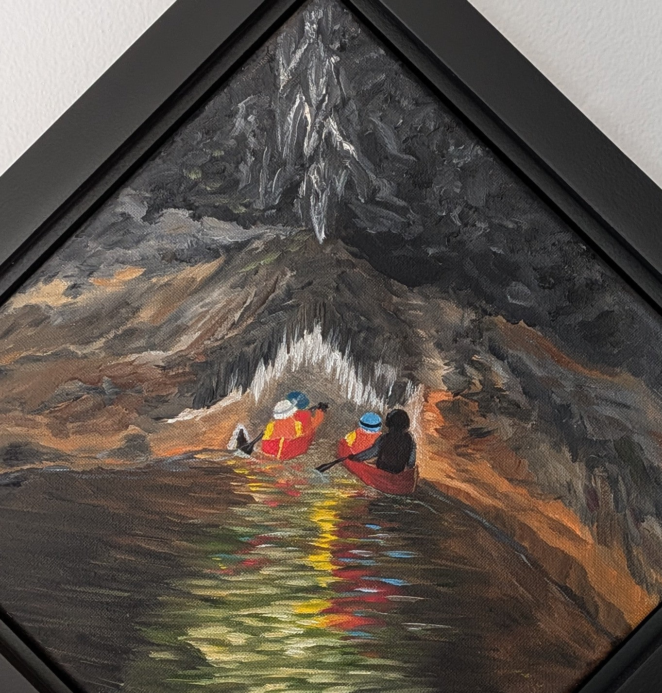 original oil painting of cavers entering a cave system with river, dark water and walls, accented by light reflections and cave formations, framed in black, diamond presentation, close-up of canoes