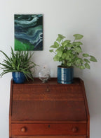 abstract poured acrylic painting on 11x14" canvas, flowing blues, greens and white create movement, second display option, shown over secretary desk
