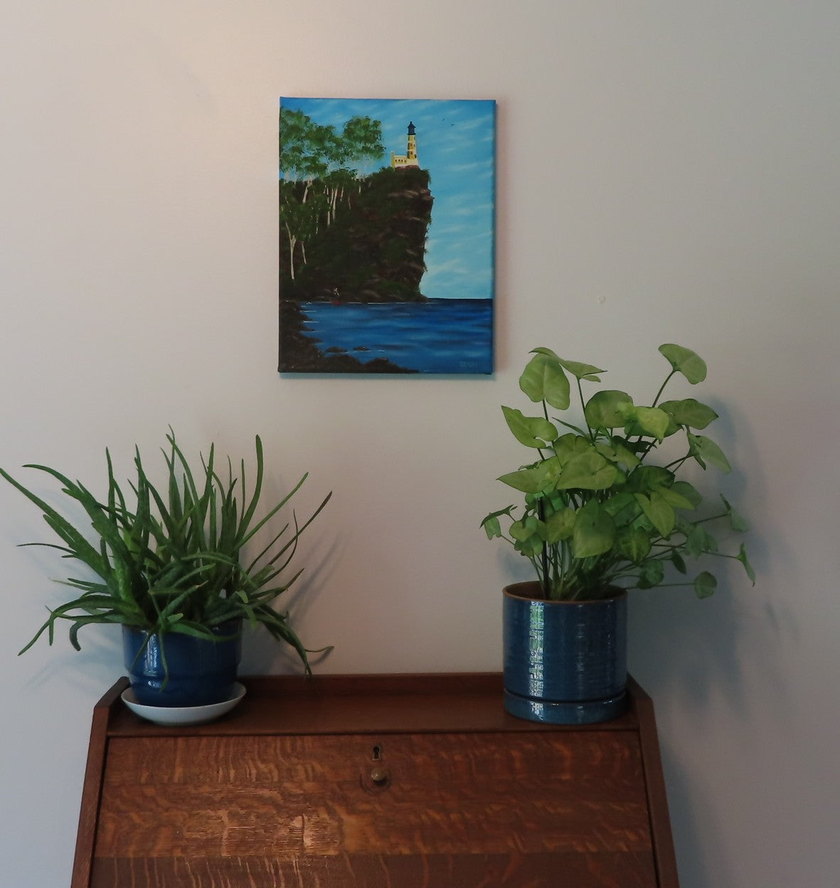 original 11x14  oil painting, lighthouse on cliff, ocean, people heading to work, unframed, pictured over a secretary desk