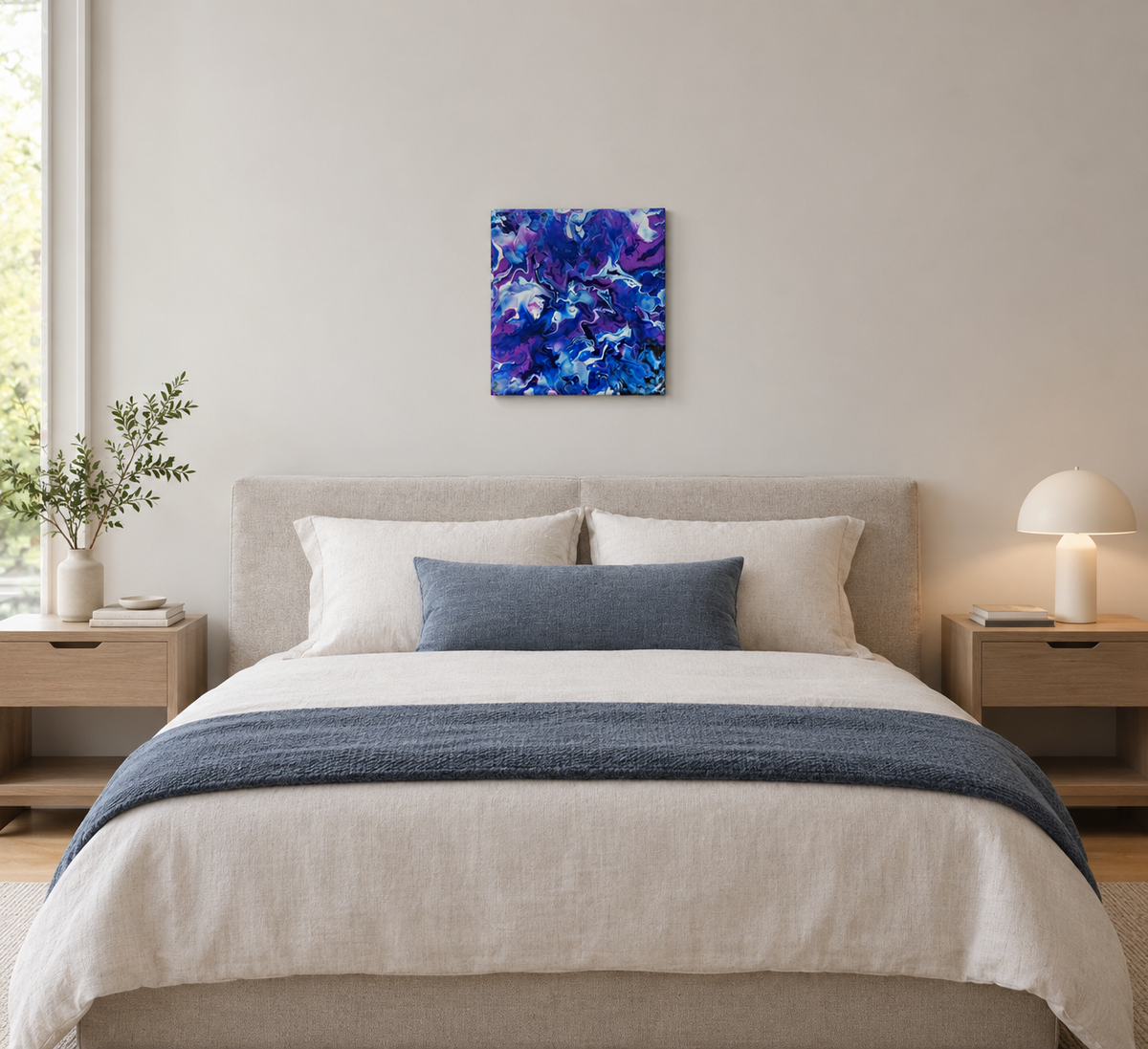original abstract poured acrylic painting on 12x12" canvas, bright swirling purples, white and rich blues seem so  energetic that they could be moving, shown here over a bed