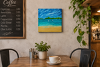 12x12" original oil painting on deep cradle canvas of turquoise ocean, sandy beach with sailboats and mountains in the distance, displayed in a cafe