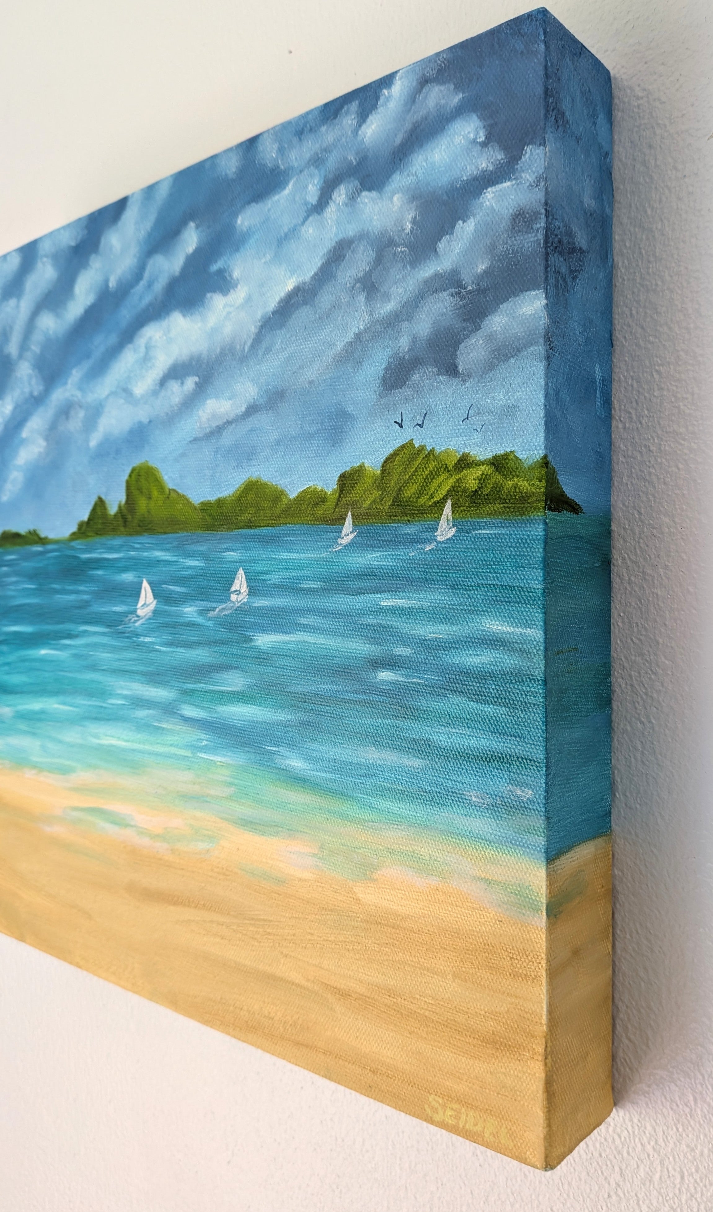 12x12" original oil painting on deep cradle canvas of turquoise ocean, sandy beach with sailboats and mountains in the distance, showing right side