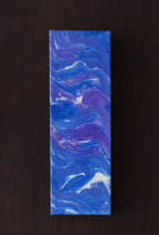 4 inches wide by 12 inches tall liquid acrylic painting with blues, purple and white, shown on a dark background. 
