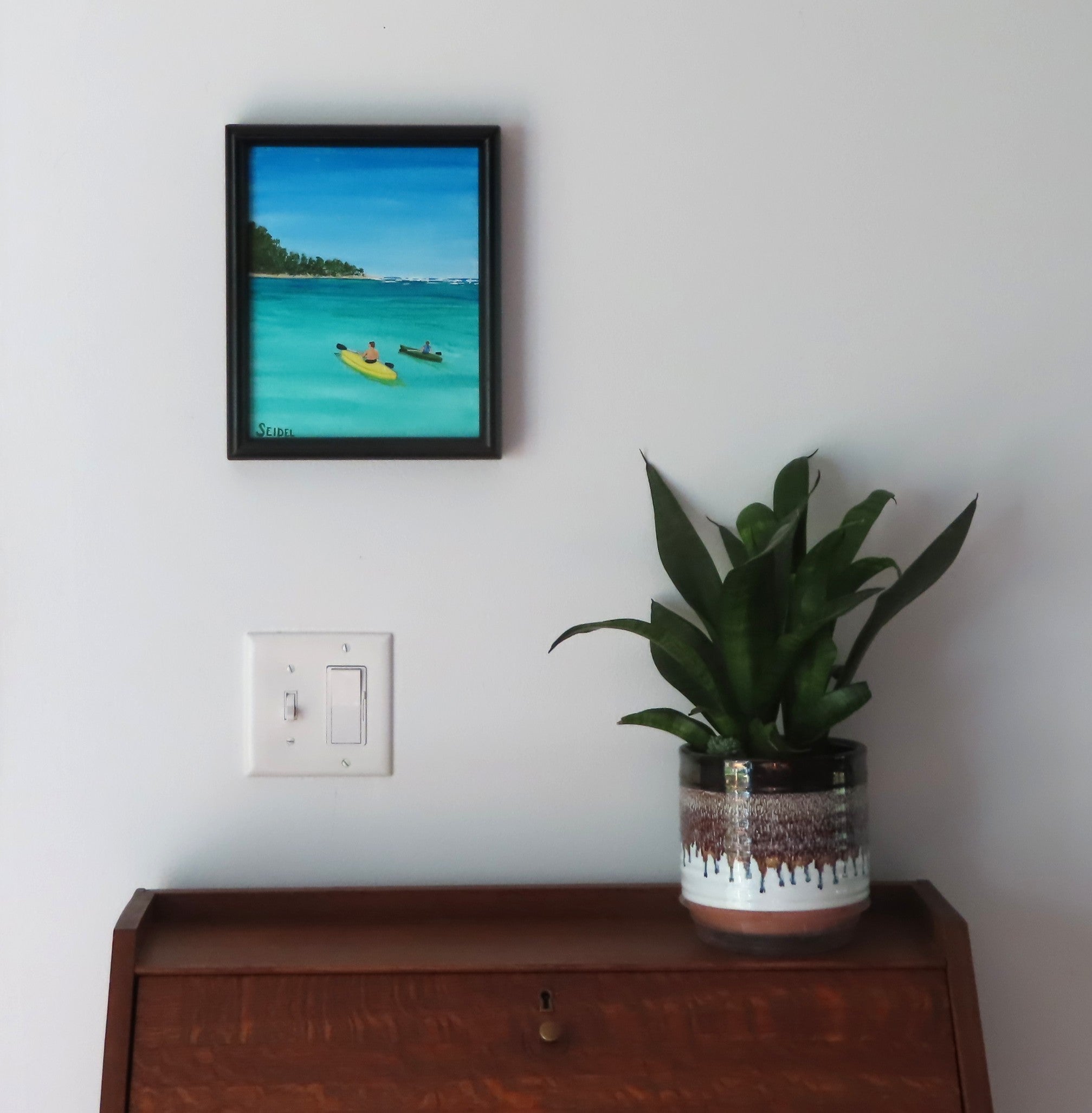 8x10" original acrylic-painting of two kayakers in a calm cove heading toward another island, beautiful turquoise water and blue sky, shown over a secretary desk