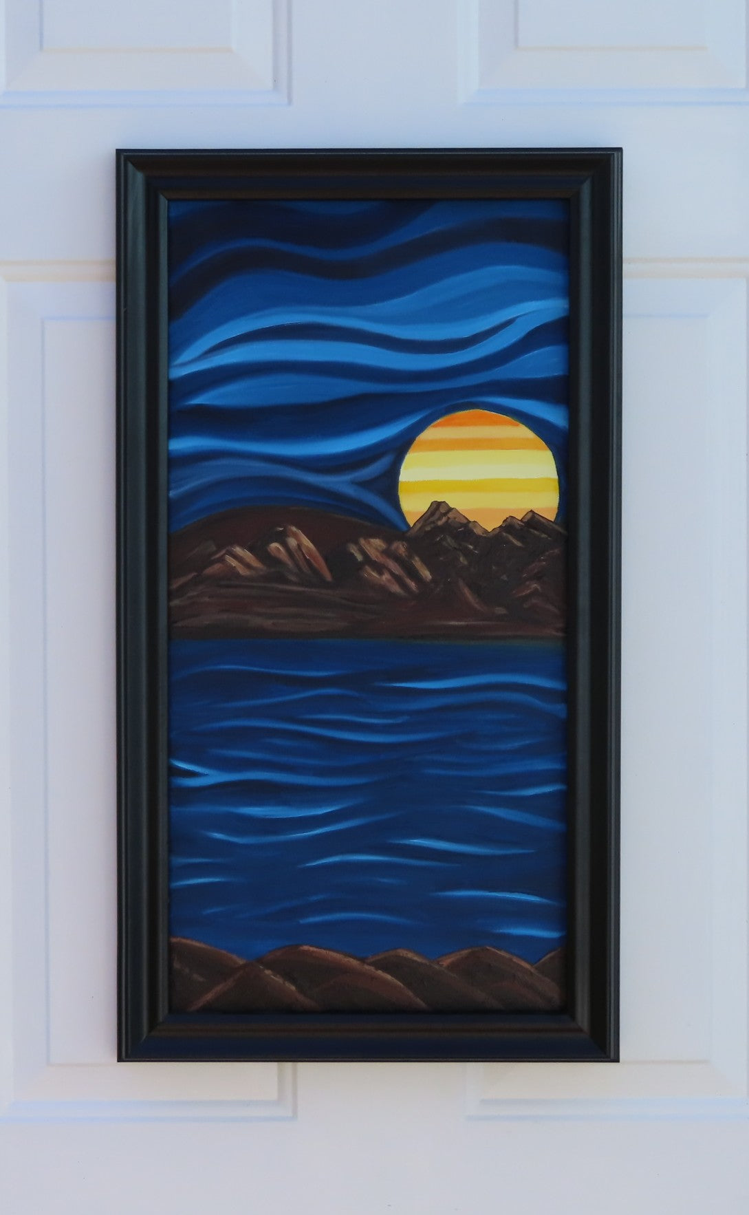 24 x 12 original oil painting, in an abstracted style, of a bright colored planet rising over the horizon in another world with cool blue colors in sky and water framed in modern black frame