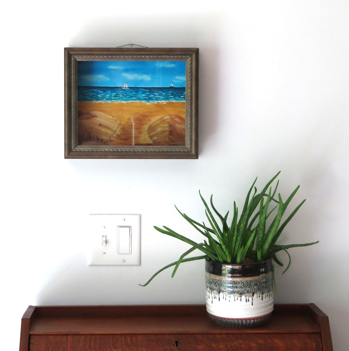 8 1/2 x 10 1/2" by 3" deep shadow box with an original acrylic painting, featuring the Atlantic ocean with sailboats. Mixed media in the foreground features sand a fence and log, shown over a secretary desk. 