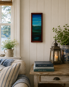 somewhat abstract view of sky, water, distant hills and birds in flight, original 10 inches by 23 1/2 inches, oil painting, repurposed hardwood frame, pictured in a lakeside cottage