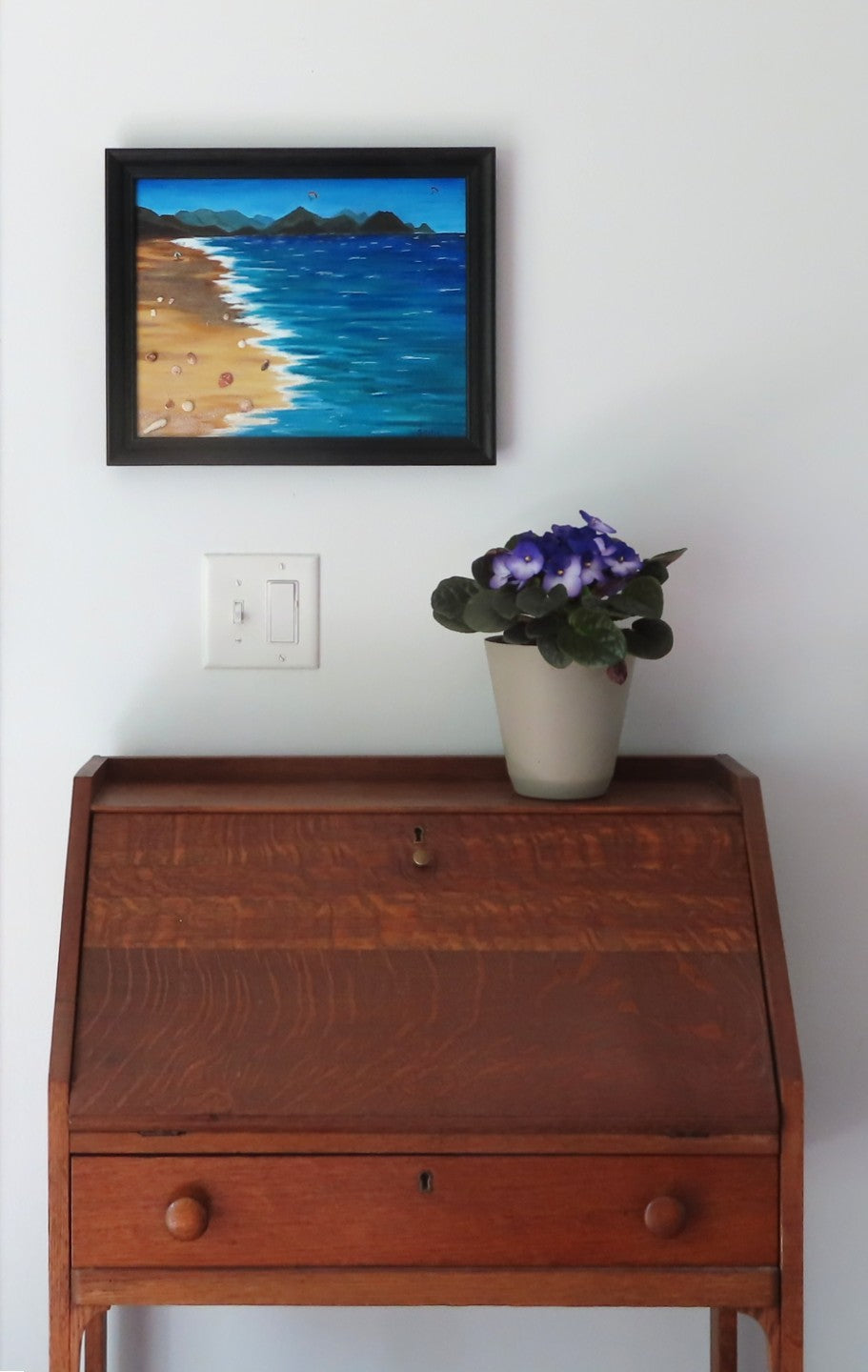 11x14" original mixed media acrylic painting, ocean, sand, shells, framed in black, shown over secretary desk
