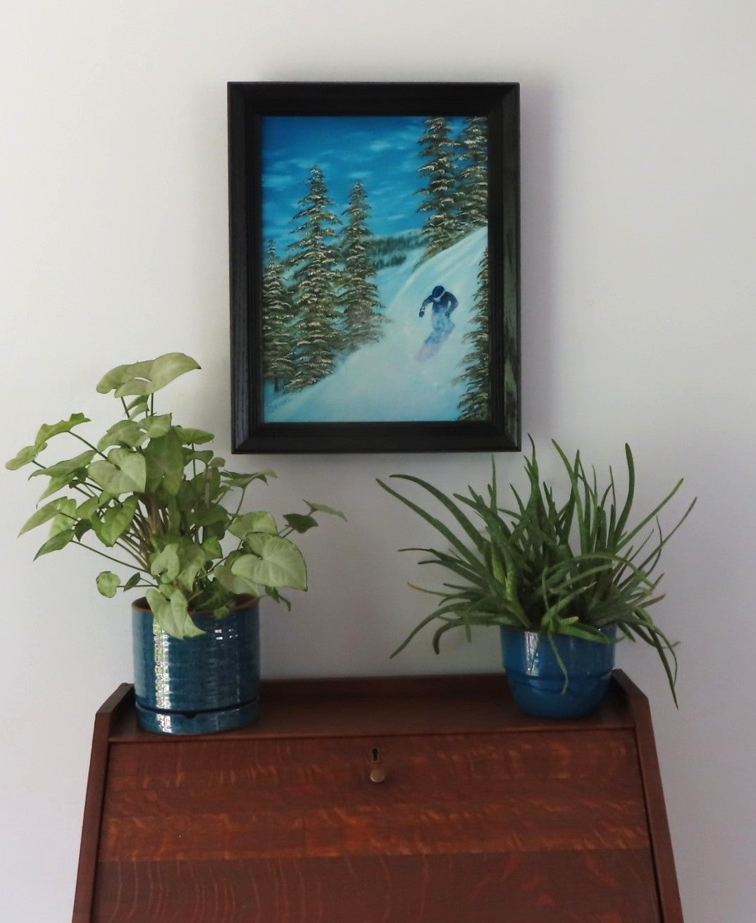original 12x16 inch oil painting of snowboarder on mountain, displayed over secretary desk