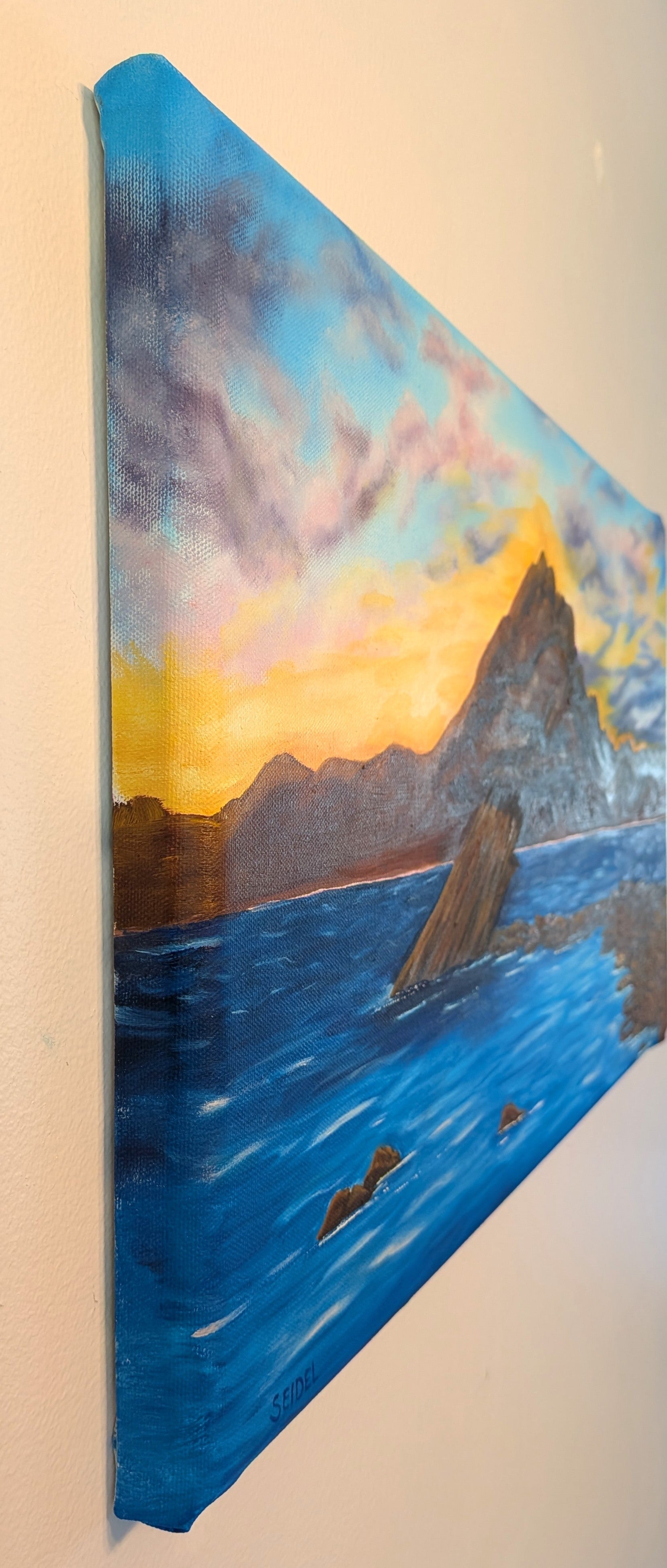 original oil painting, 14x24 beveled canvas, delicate pastel clouds in evening sky, contrasted by bold textured mountains and shadowed waters showing detail of left side 