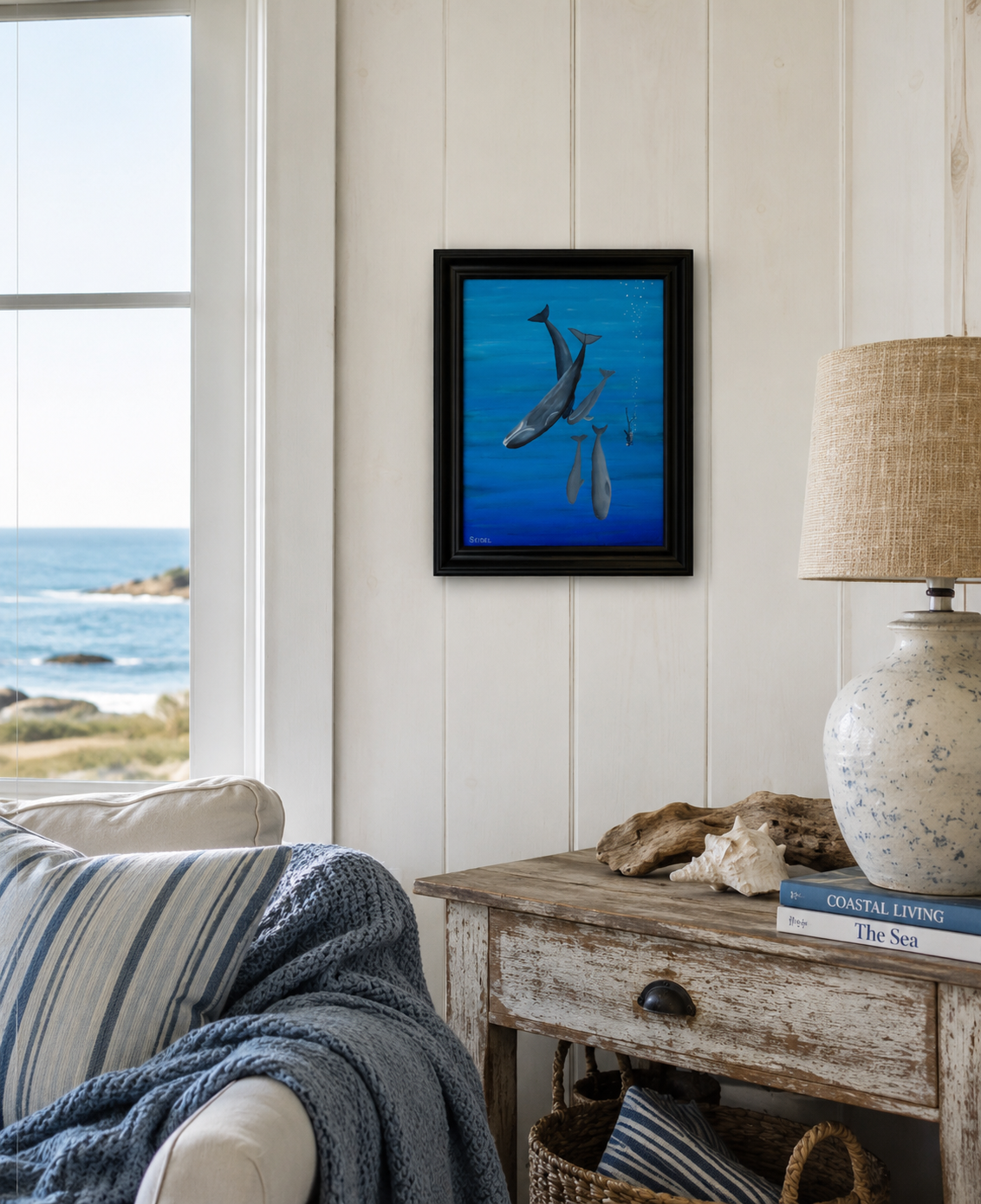 11x14 original oil painting of a scuba diver swimming with whales, framed shown in a seaside cottage