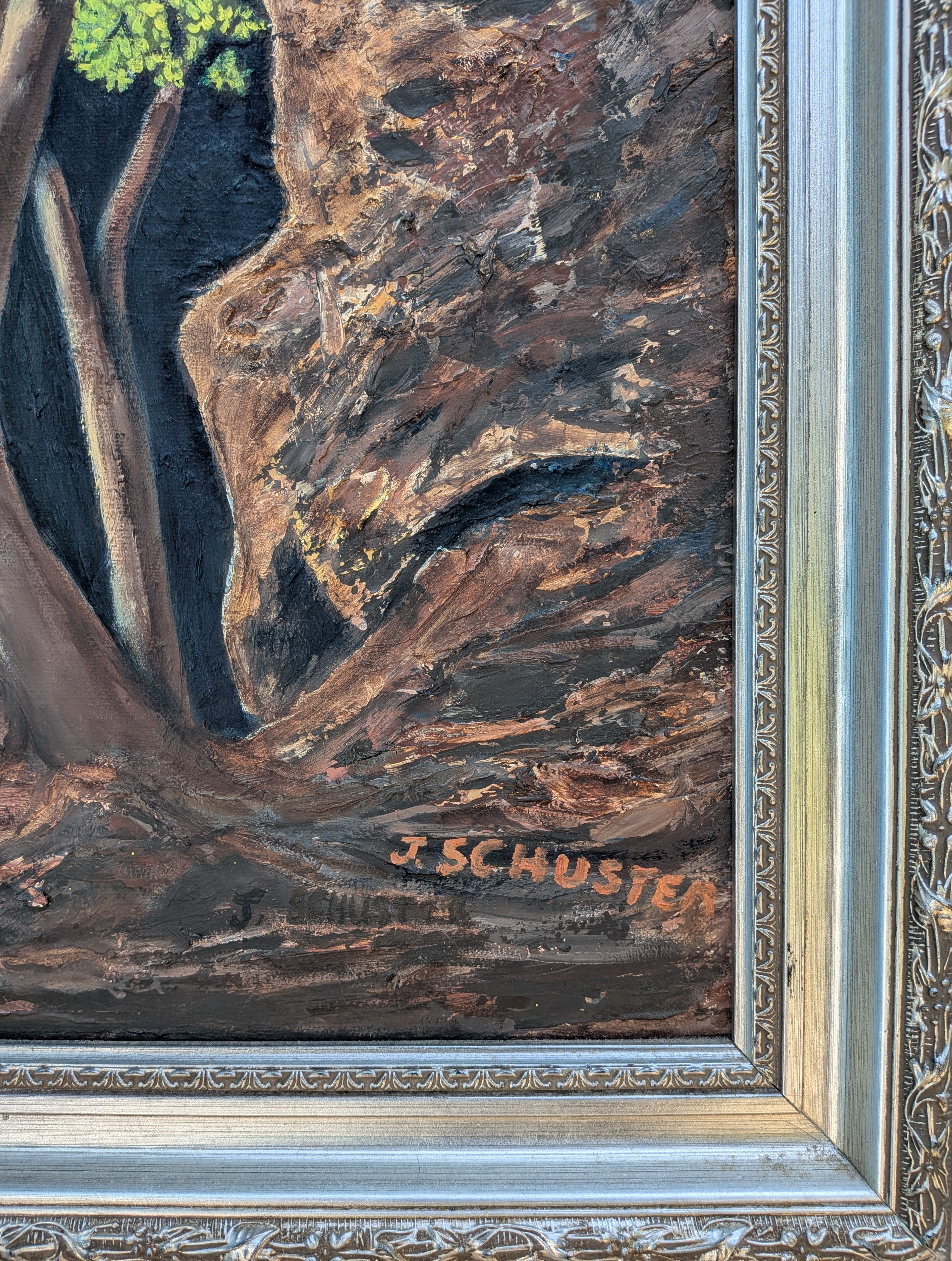 An original 16x20 oil painting on canvas featuring a lone tree with bright green leaves, illuminated by sunlight, with a dark, mysterious background and a rocky cavern, displayed in an ornate wood frame, signature