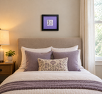 An 8x8" original framed artwork with a purple background and a black frame, featuring a textual message 'You are a work of art' alongside a key, shown over a bed.
