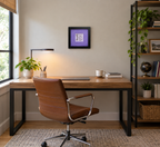 An 8x8" original framed artwork with a purple background and a black frame, featuring a textual message 'You are a work of art' alongside a key, shown in a modern office