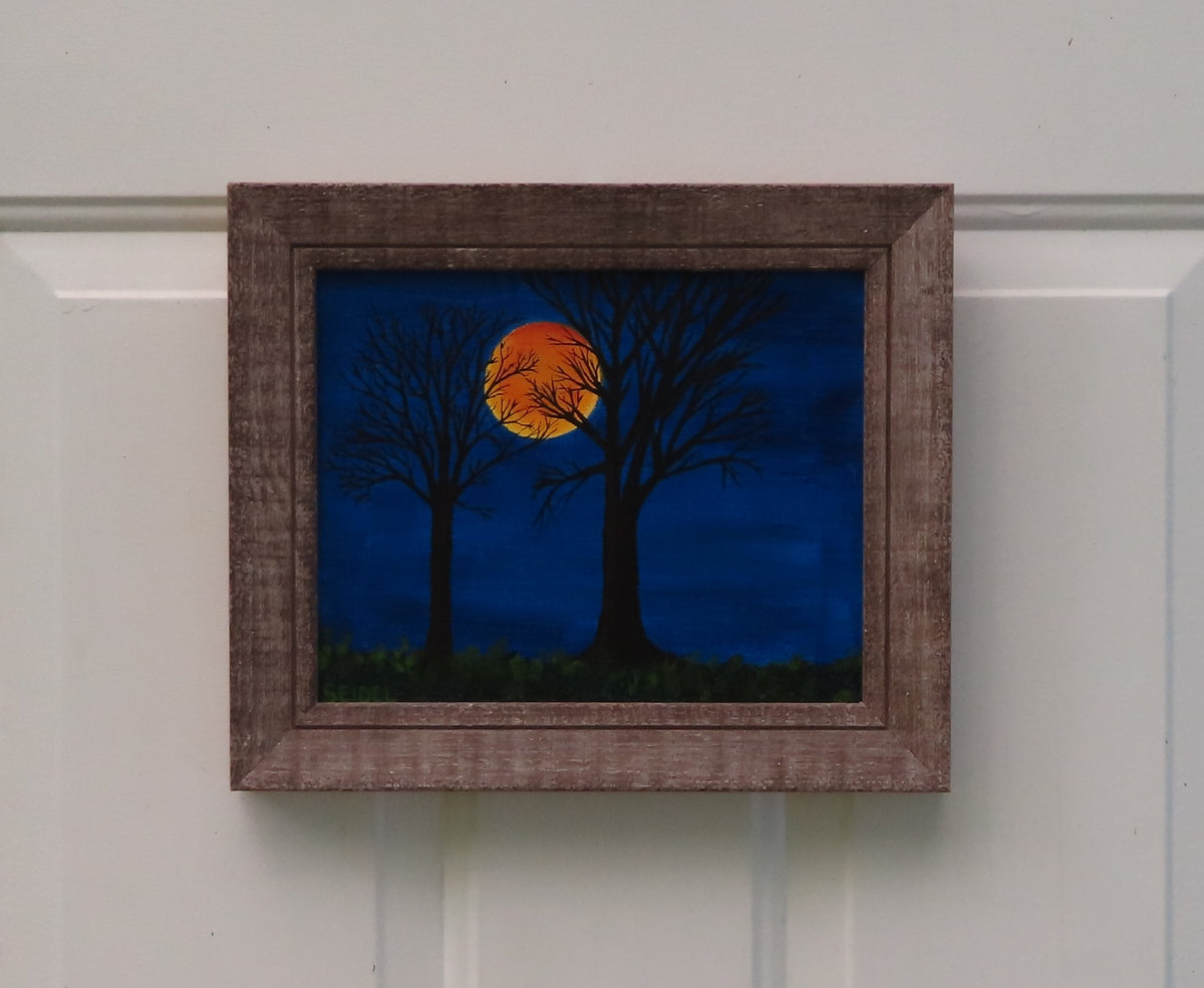 8x10" original acrylic painting, harvest moon, trees, framed, shown in dark-lit room