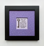 An 8x8" original framed artwork with a purple background and a black frame, featuring a textual message 'You are a work of art' alongside a key.